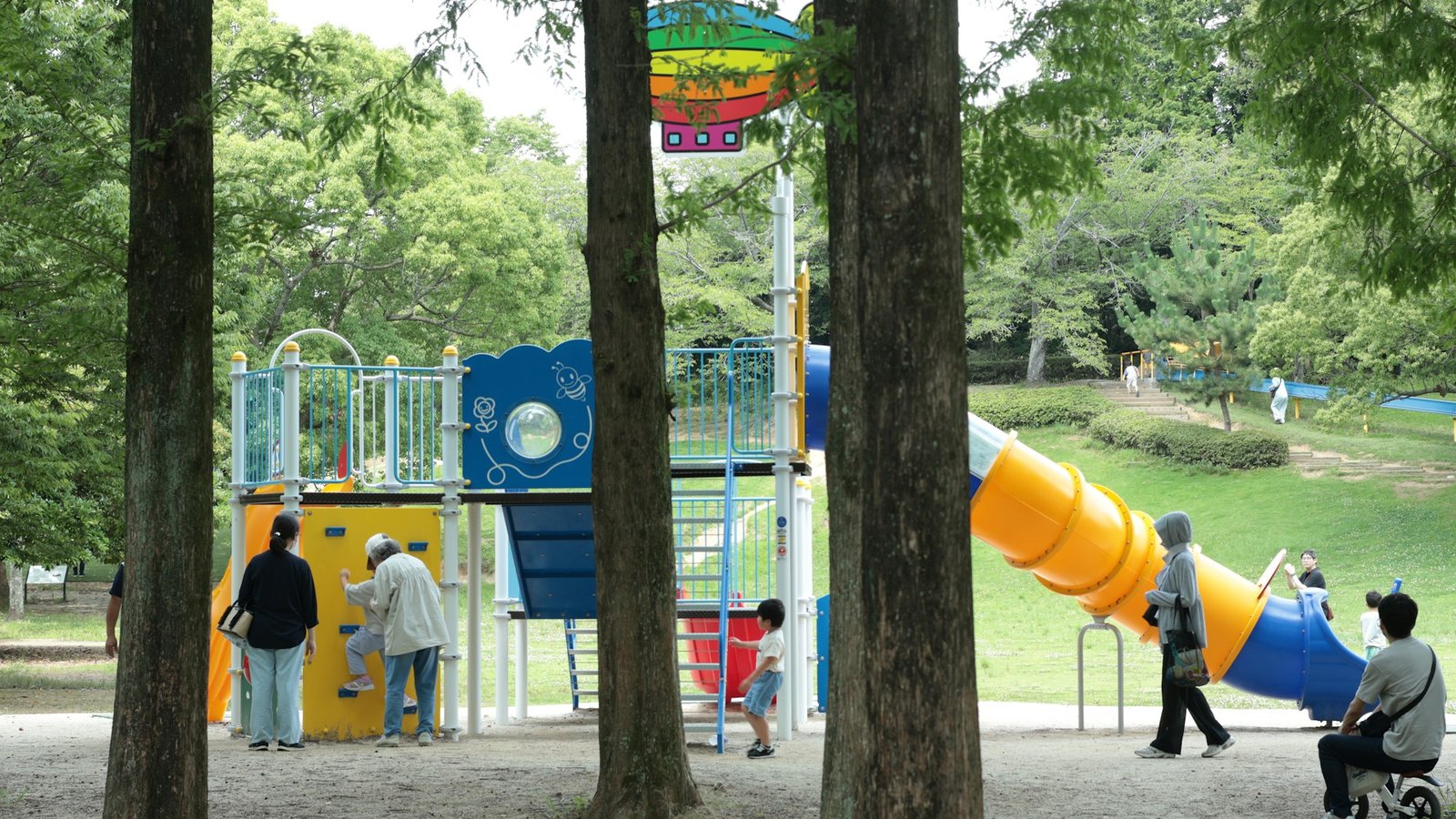 公園の遊具広場で遊ぶ親子